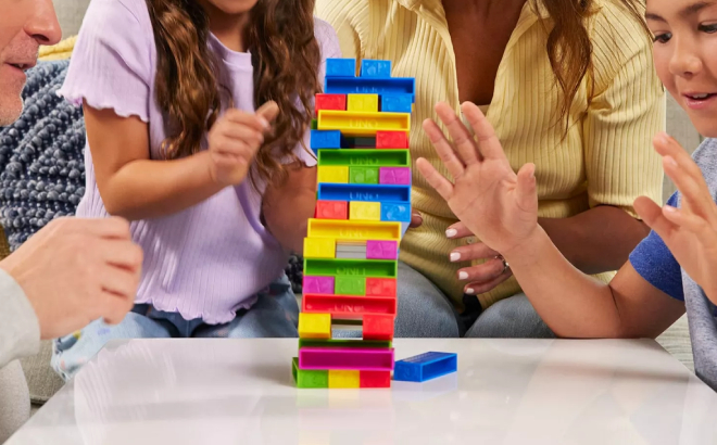 A Family Playing with Mattel UNO Stacko Game A Family Playing with Mattel UNO Stacko Game