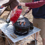 A Man Preparing Meat on the Coleman RoadTrip Portable Tabletop Grill