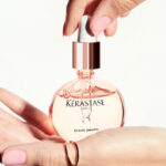 A Person Holding Kerastase Gloss Absolu Glaze Drops Anti Frizz Hair Oil
