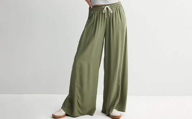 A Person Wearing Juniors SO High Rise Baggy Wide Leg Pants in Drew Green