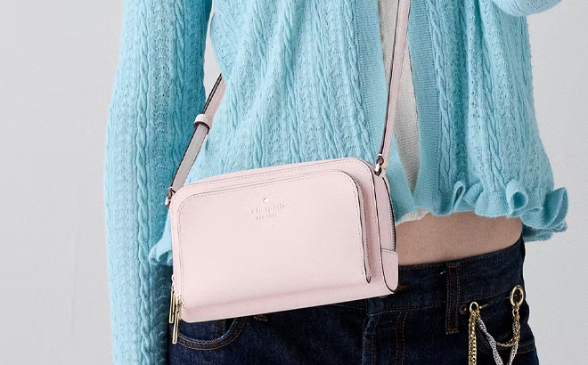 A Person Wearing Kate Spade Staci Mini Crossbody Bag in Shimmer Pink Color
