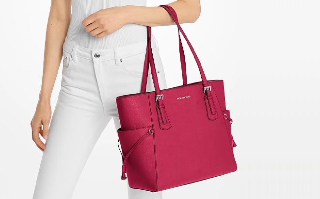 A Woman Holding Michael Kors Voyager Large Saffiano Leather Tote Bag in Raspberry