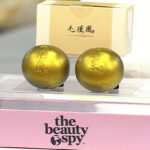 The Beauty Spy Lalachuu Gold Shampoo Ball Duo on a Product Stand