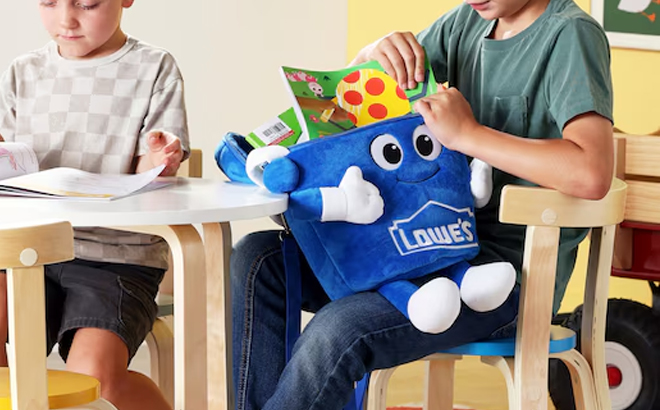 A Kid Holding the Lowes Big Blue Plush Backpack A Kid Holding the Lowes Big Blue Plush Backpack