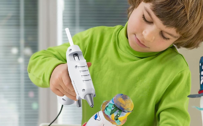 A Kid Using Mini Hot Glue Gun A Kid Using Mini Hot Glue Gun