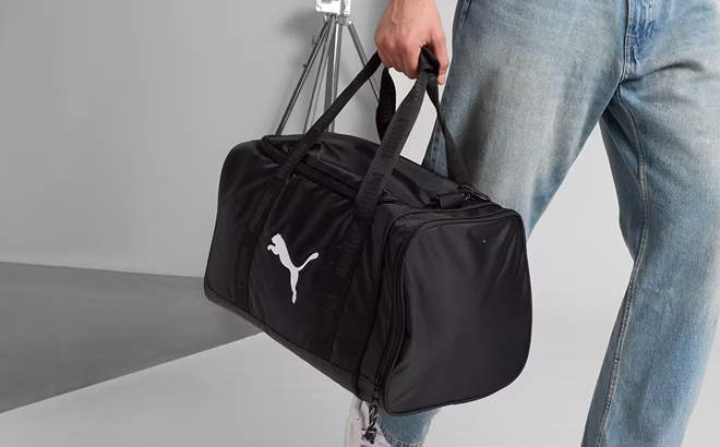A Man Holding Puma Training Small Gym Duffle Bag