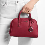A Person Holding Michael Kors Ashton Small Messenger Bag 1