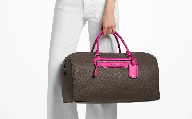 A Person Holding Michael Kors Jet Set Travel Extra Large Signature Logo Weekender Bag A Person Holding Michael Kors Jet Set Travel Extra Large Signature Logo Weekender Bag
