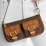 A Person Holding Michael Kors Zoe Small Signature Logo Pochette
