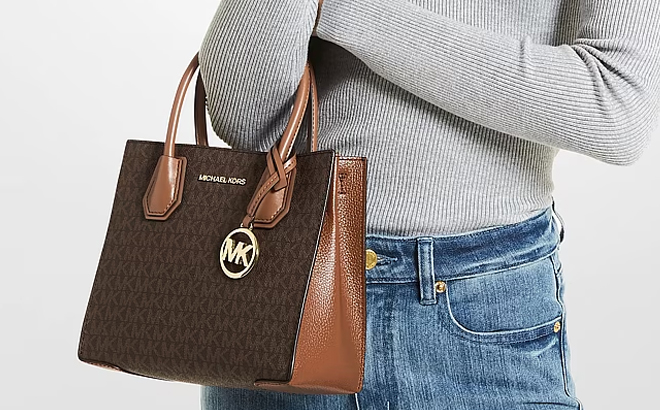 A Woman Holding Michael Kors Mercer Medium Logo and Leather Accordion Crossbody Bag