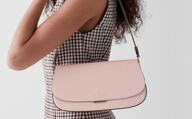 A Woman Wearing Kate Spade Quinn Shoulder Bag in Rose Smoke