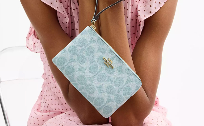 Person Holding Coach Corner Zip Wristlet in Light Blue