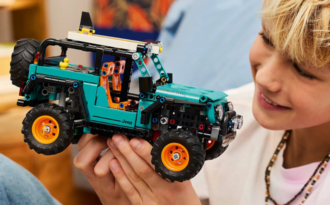A Boy Holding LEGO Technic Jeep Wrangler Rubicon SUV