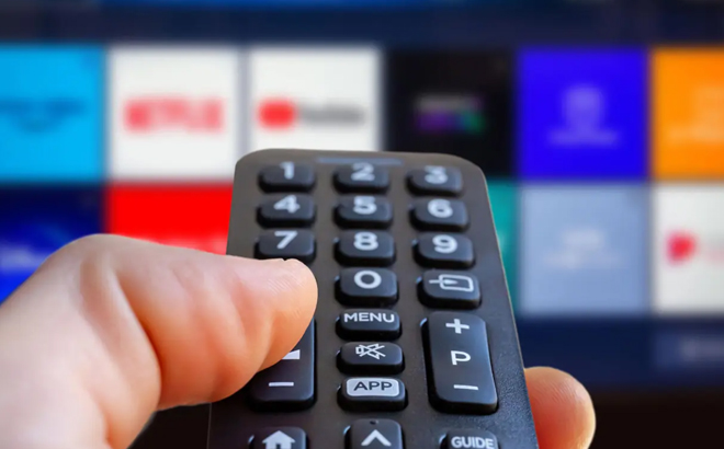 A Person Holding a Remote Control in Front of a Smart TV