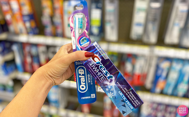 A Person Holding Crest Toothbrush and Toothpaste