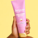 A Person Holding the Jergens Shea Cocoa Hand Body Lotion For Dry Skin