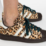 A Person Wearing Adidas Womens Superstar II Athletic Shoes