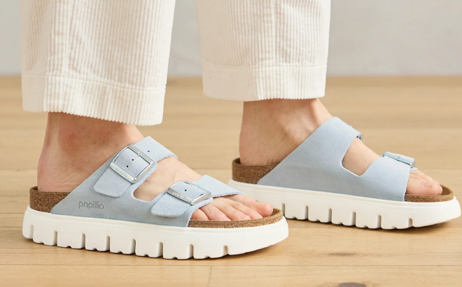 A Person Wearing Papillio by Birkenstock Arizona Platform Womens Slide Sandals in Baby Blue A Person Wearing Papillio by Birkenstock Arizona Platform Womens Slide Sandals in Baby Blue