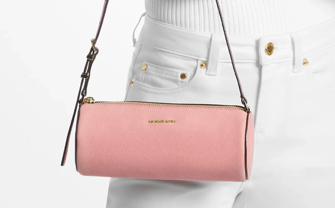 A Woman Holding Michael Kors Izzy Small Barrel Pouchette Bag in Primrose