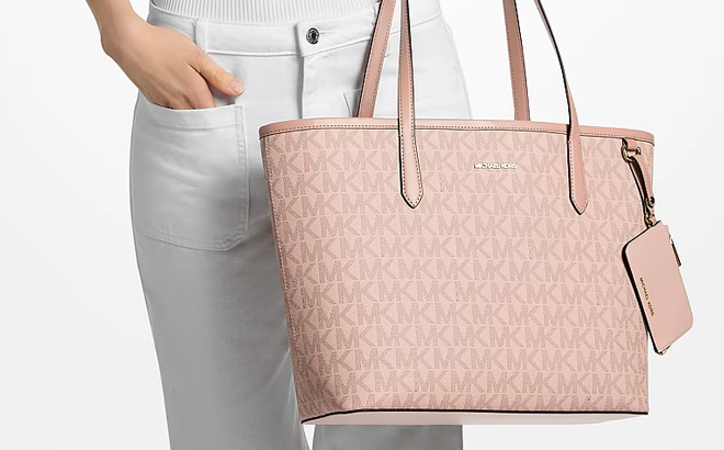 A Woman Holding Michael Kors Jet Set Large Signature Logo Tote Bag in Ballet