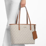 A Woman Holding Michael Kors Jet Set Large Signature Logo Tote BagJet Set Large Signature Logo Tote Bag