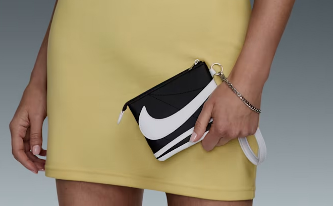 A Woman Holding Nike Icon Cortez Wristlet