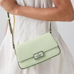 A Woman Wearing Kate Spade Reegan Mini Flap Crossbody in Lime Frosting