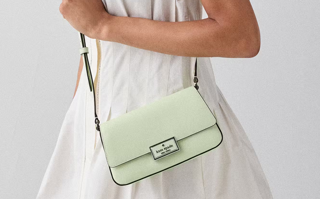 A Woman Wearing Kate Spade Reegan Mini Flap Crossbody in Lime Frosting