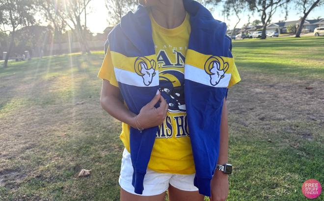 A Woman Wearing Officially Licensed NFL T Shirt and Pullover Hooded Sweatshirt A Woman Wearing Officially Licensed NFL T Shirt and Pullover Hooded Sweatshirt