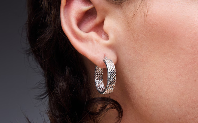 A Woman Wearing Zales Diamond Cut Hoop Earrings in Sterling Silver