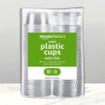 Amazon Basics Disposable Plastic To Go Cups and Lids 50 Count on a Table