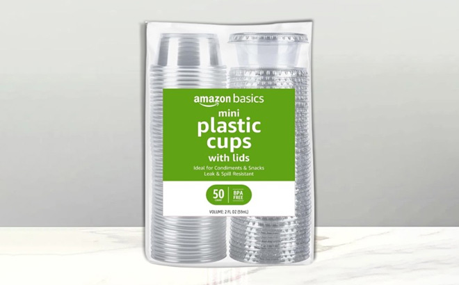 Amazon Basics Disposable Plastic To Go Cups and Lids 50 Count on a Table