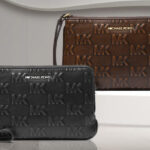 Michael Kors Jet Set Travel Small Burnished Logo Embossed Wristlets on the Table