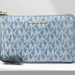 Michael Kors Jet Set Travel Small Signature Logo Print Denim Wristlet on the Table