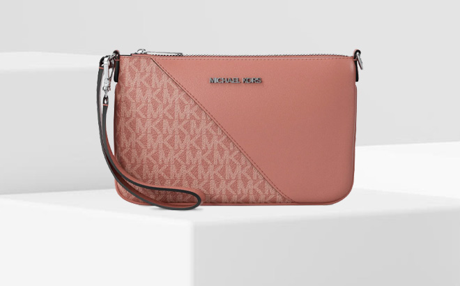 Michael Kors Jet Set Travel Small Signature Logo and Smooth Wristlet on the Table Michael Kors Jet Set Travel Small Signature Logo and Smooth Wristlet on the Table