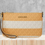 Michael Kors Jet Set Travel Small Striped Signature Logo Convertible Wristlet on the Table