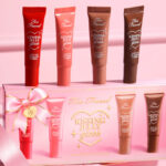 Too Faced 4 Piece Kissing Jelly Lip Oil Gloss Collection Set on the Table