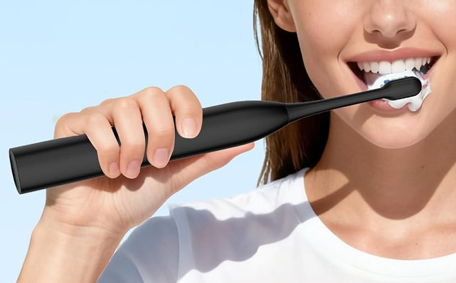 A Person Holding Electric Toothbrush A Person Holding Electric Toothbrush