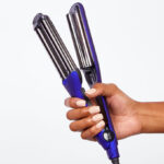 A Person Holding ION Titanium Pro Triple Barrel Waver