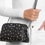 A Person Holding Michael Kors Ashton Extra Small Floral Printed Camera Crossbody Bag