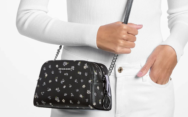 A Person Holding Michael Kors Ashton Extra Small Floral Printed Camera Crossbody Bag