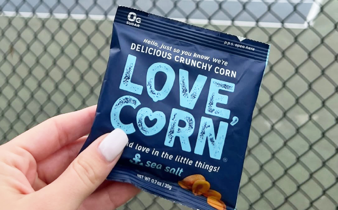 A Person Holding a Small Bag of Love Corn Sea Salt Crunchy Roasted Corn Snack A Person Holding a Small Bag of Love Corn Sea Salt Crunchy Roasted Corn Snack
