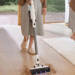 A Woman Cleaning with the Tineco GO Cordless 2 in 1 Stick Handheld Vacuum