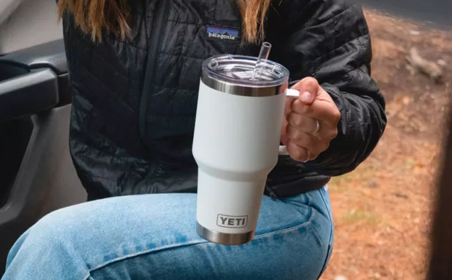 A Woman Holding YETI Rambler Mug with Straw Lid in White A Woman Holding YETI Rambler Mug with Straw Lid in White
