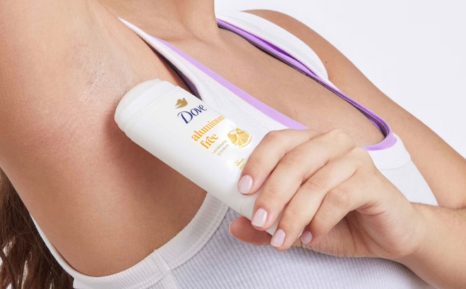 A Woman Using Dove Aluminum Free Deodorant Stick for 72 Hour Odor Protection in Citrus Pop A Woman Using Dove Aluminum Free Deodorant Stick for 72 Hour Odor Protection in Citrus Pop