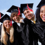 Smiling College Students wearing Robes and Caps