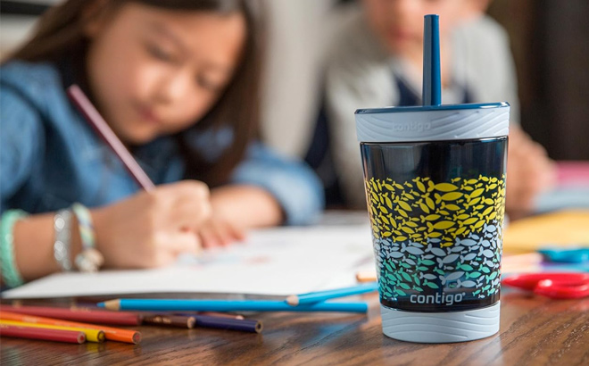 A Contigo Kids Spill Proof 14oz Tumbler with Straw and a Girl Drawing in The Background