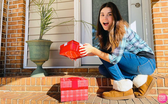 A Person Holding a Gift Box in Front of a House