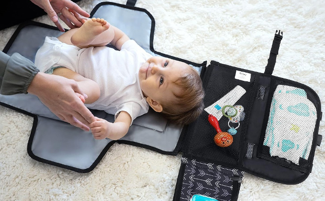 Mother Changing Diapers of a Baby on a Portable Diaper Changing Pad